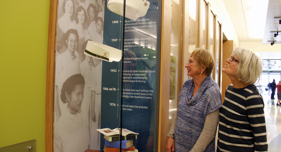 Two former nurses look at historical display.
