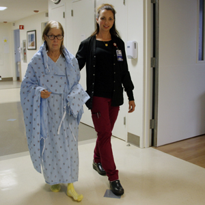 Stefanie Beltramo, RN, helps Juliette Anthony to take a brief walk.