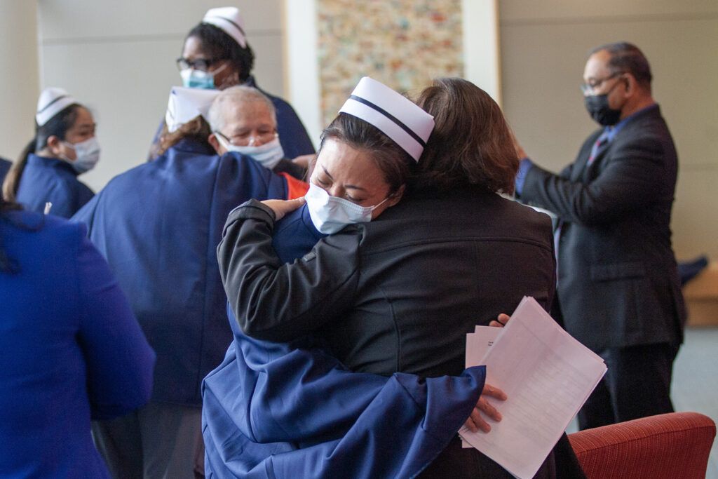 Nurses from the Kaiser Permanente Nurse Honor Guard embrace family members of the late Leticia Dicioco-Reyes, RN.