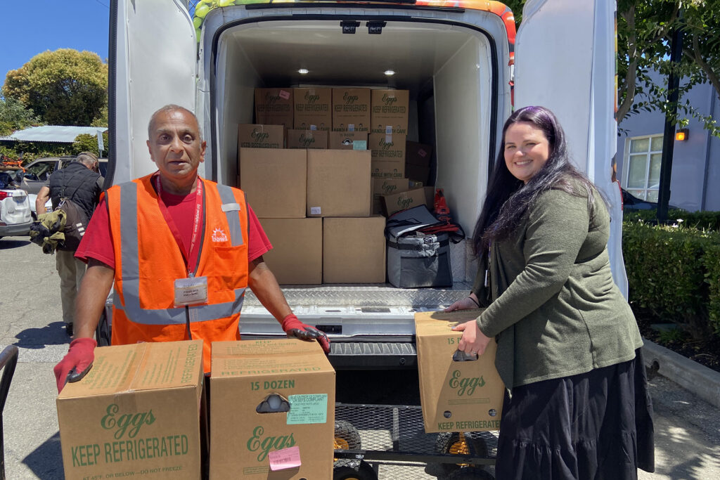 Paddy Iyer, executive director of Daily Bowl, right, and Rochelle Pierce, director of food services Kaiser Permanente Fremont, unload food at Bay Area Community Services South County Wellness Center.