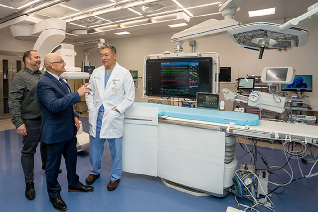 Three men standing in a heart lab